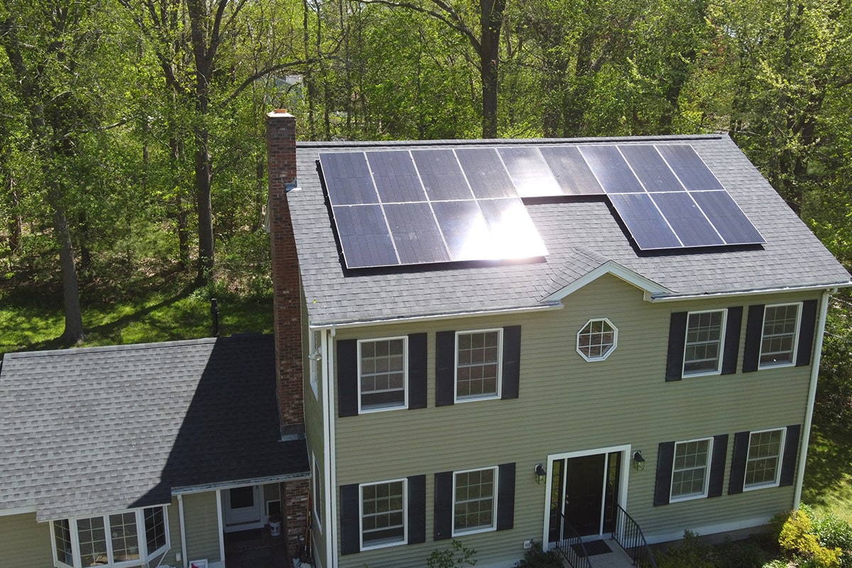 Here is an image of residential solar panels in NH, taken from a drone camera. We are a New Hampshire solar installer and can install solar panels on the roof of a home or elsewhere on the property.