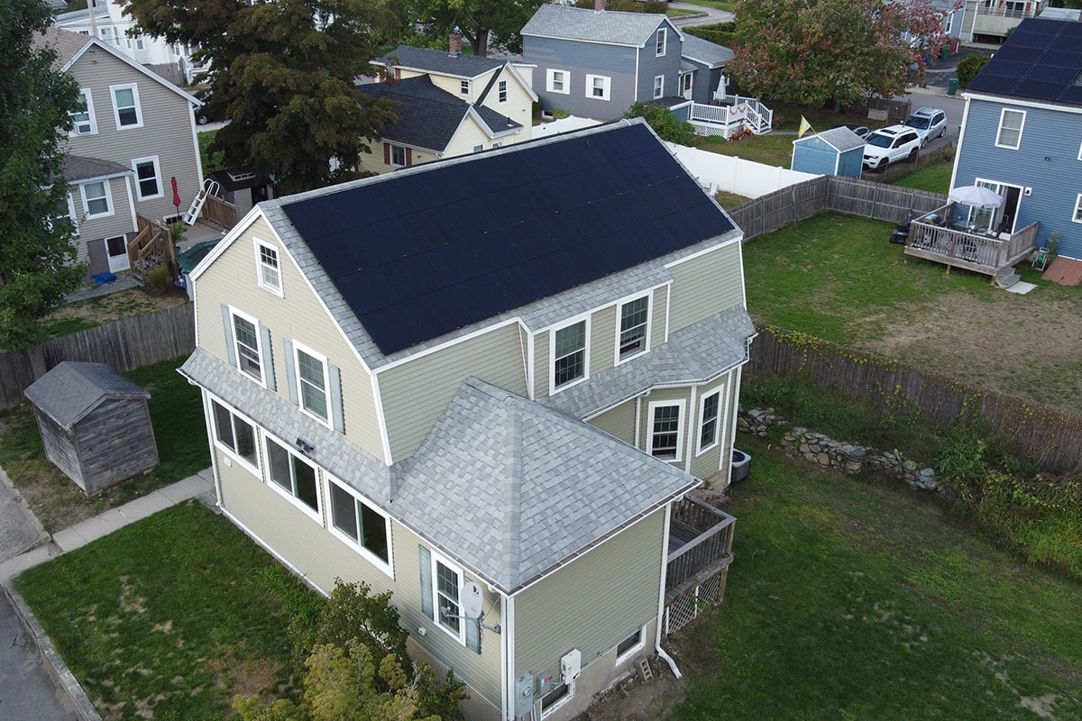 Image of RI residential solar panel installation, on the roof of a big house. We are Rhode Island solar contractors that install solar panels all over New England.