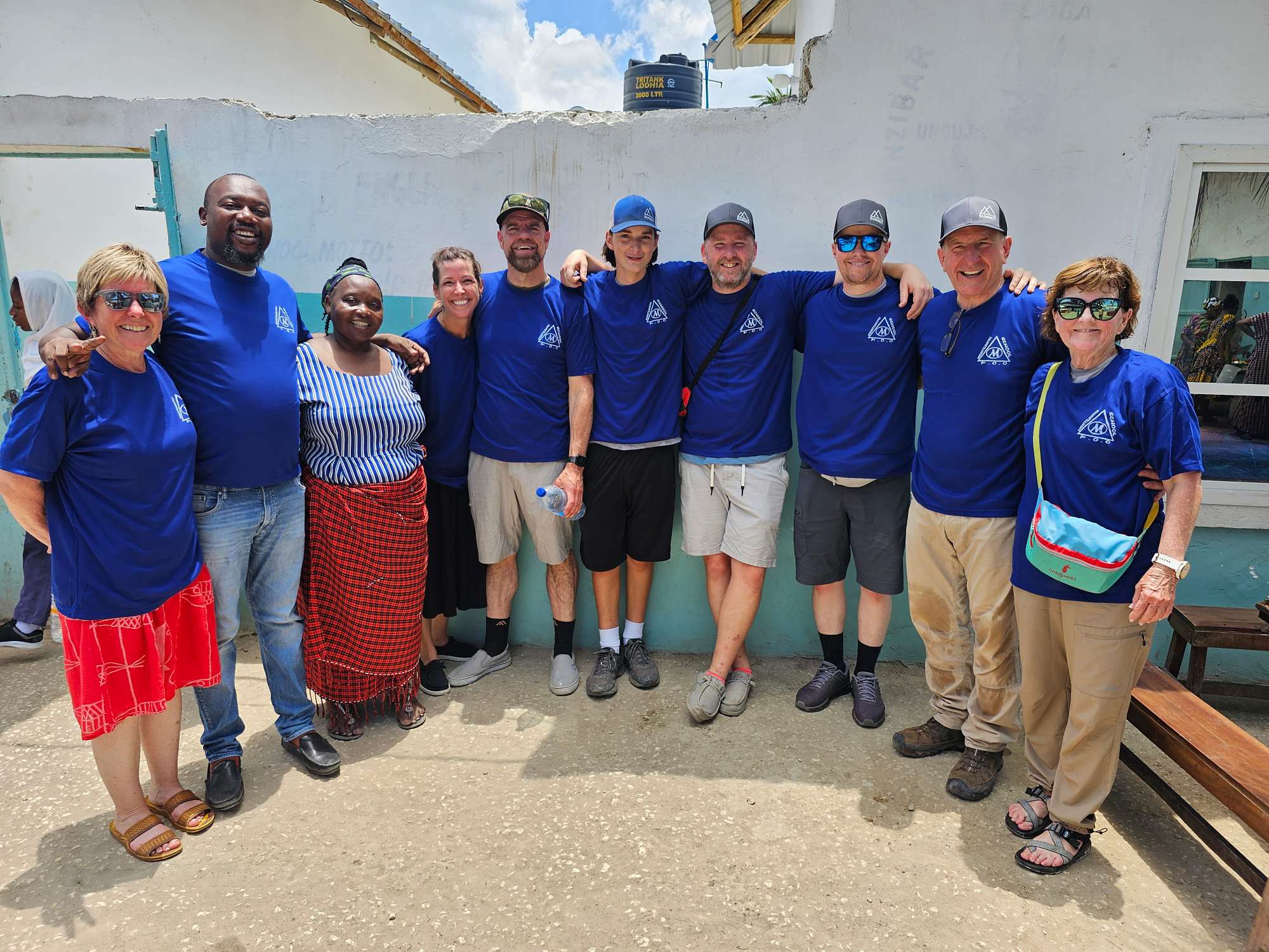  Suzana Maziku, Founder and Head of the Montessori Orphanage and School (third from the left) with Summit Energy's James Truax, Chief Revenue Officer (fifth from the left) and Summit's Eric Israelsen, Cofounder, and Chief Empower Officer (third from right) along with friends and members of their families after a full day assisting with the newly donated construction.  